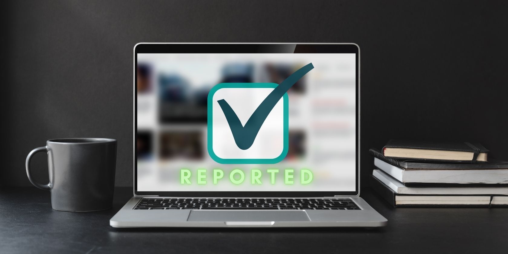 Laptop on a desk with the word reported seen on the screen