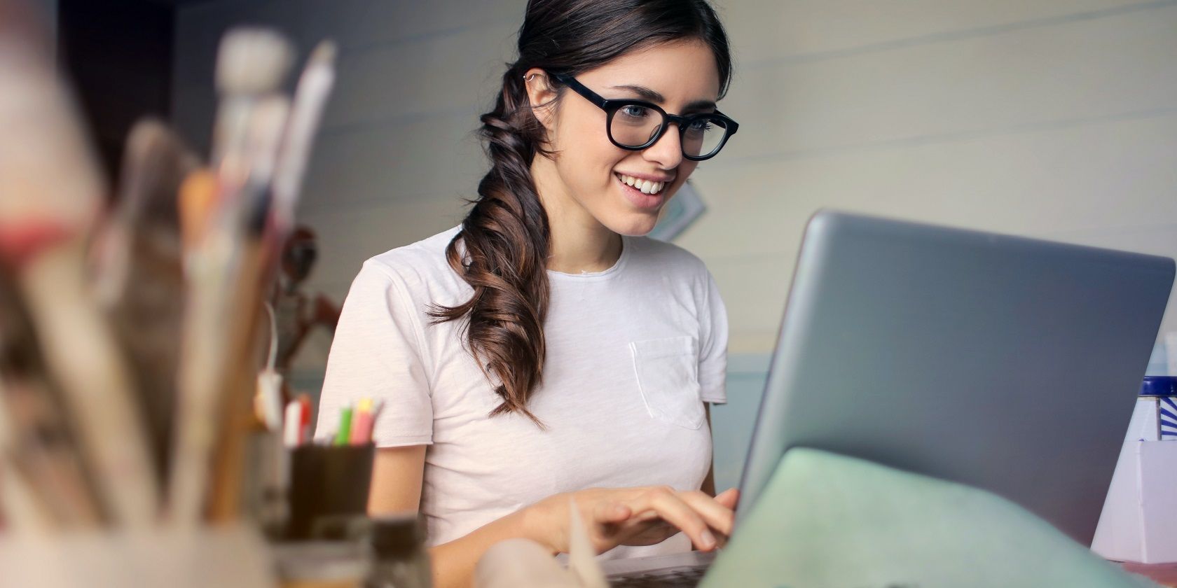 7 Trang Mua Hàng Trả Lại Trực Tuyến woman using laptop and smiling