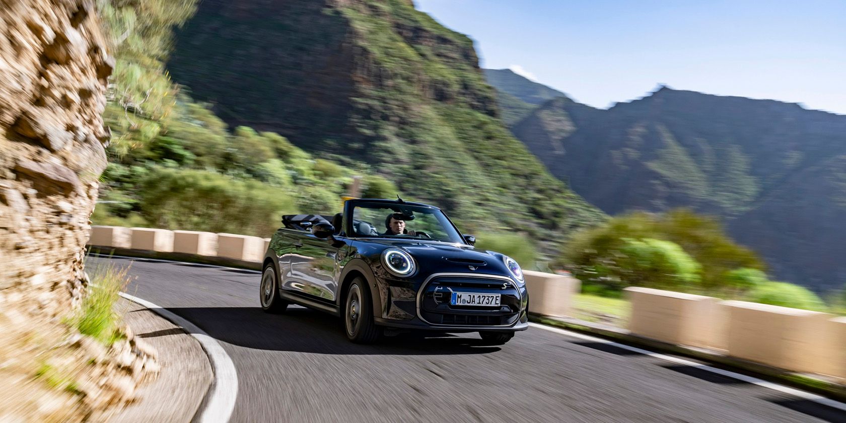 Mini Cooper mui trần chạy điện trên đường núi.