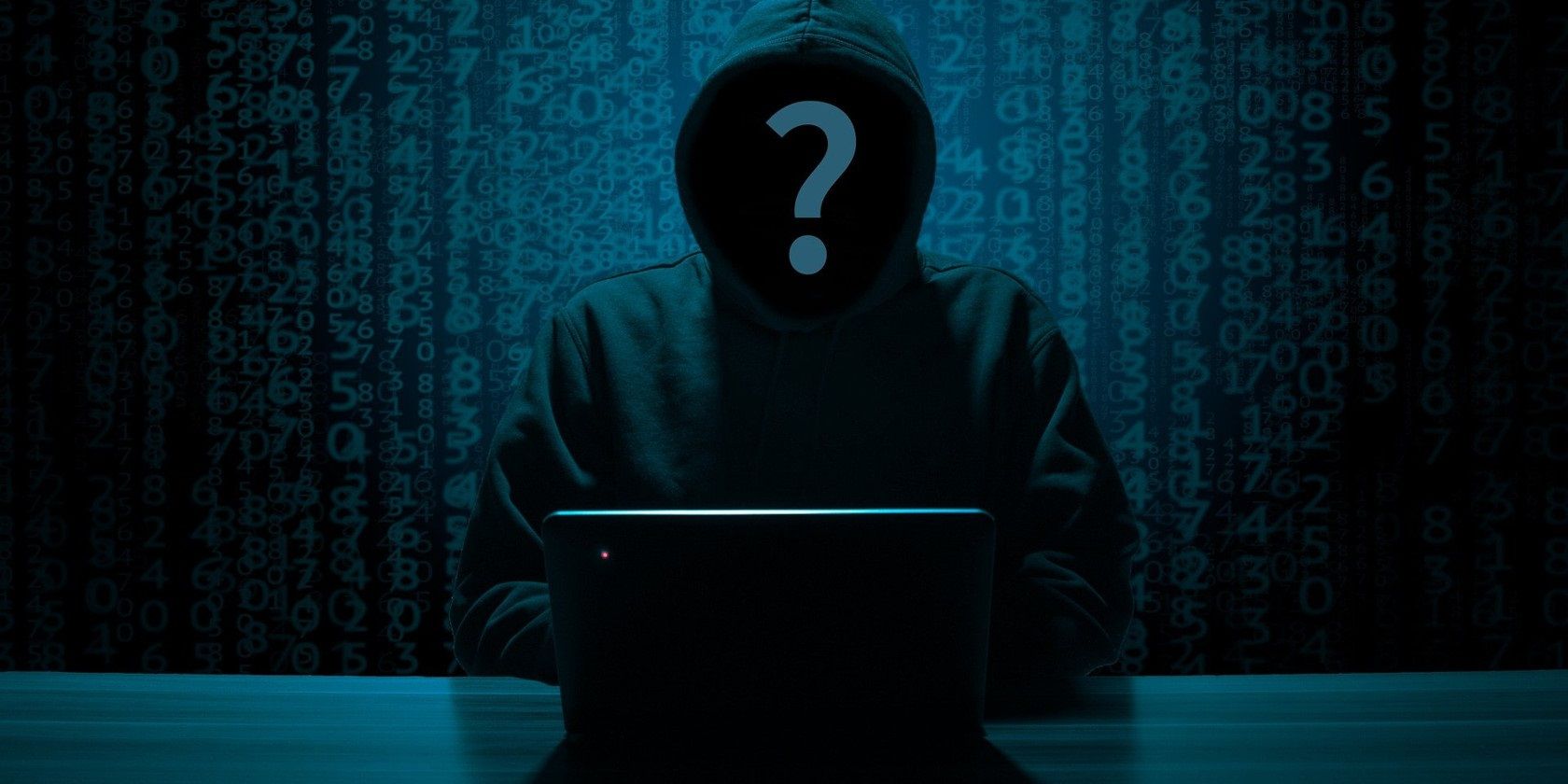 Vi phạm dữ liệu xảy ra như thế nào? 6 biến cần chú ý Anonymous hacker's face in a black hoody with a PC on the table