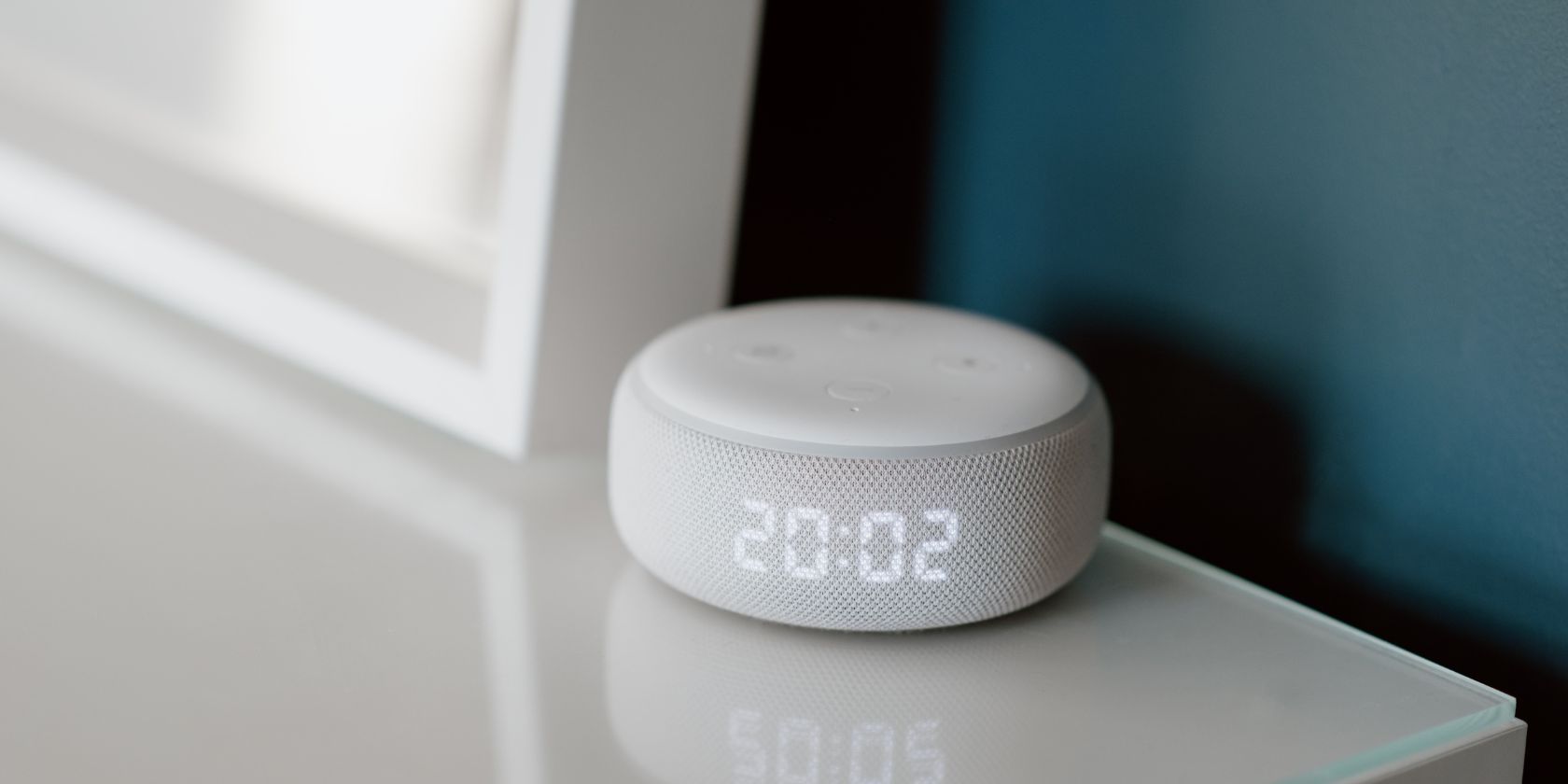Amazon Echo Dot màu trắng ngồi ở góc bàn trắng