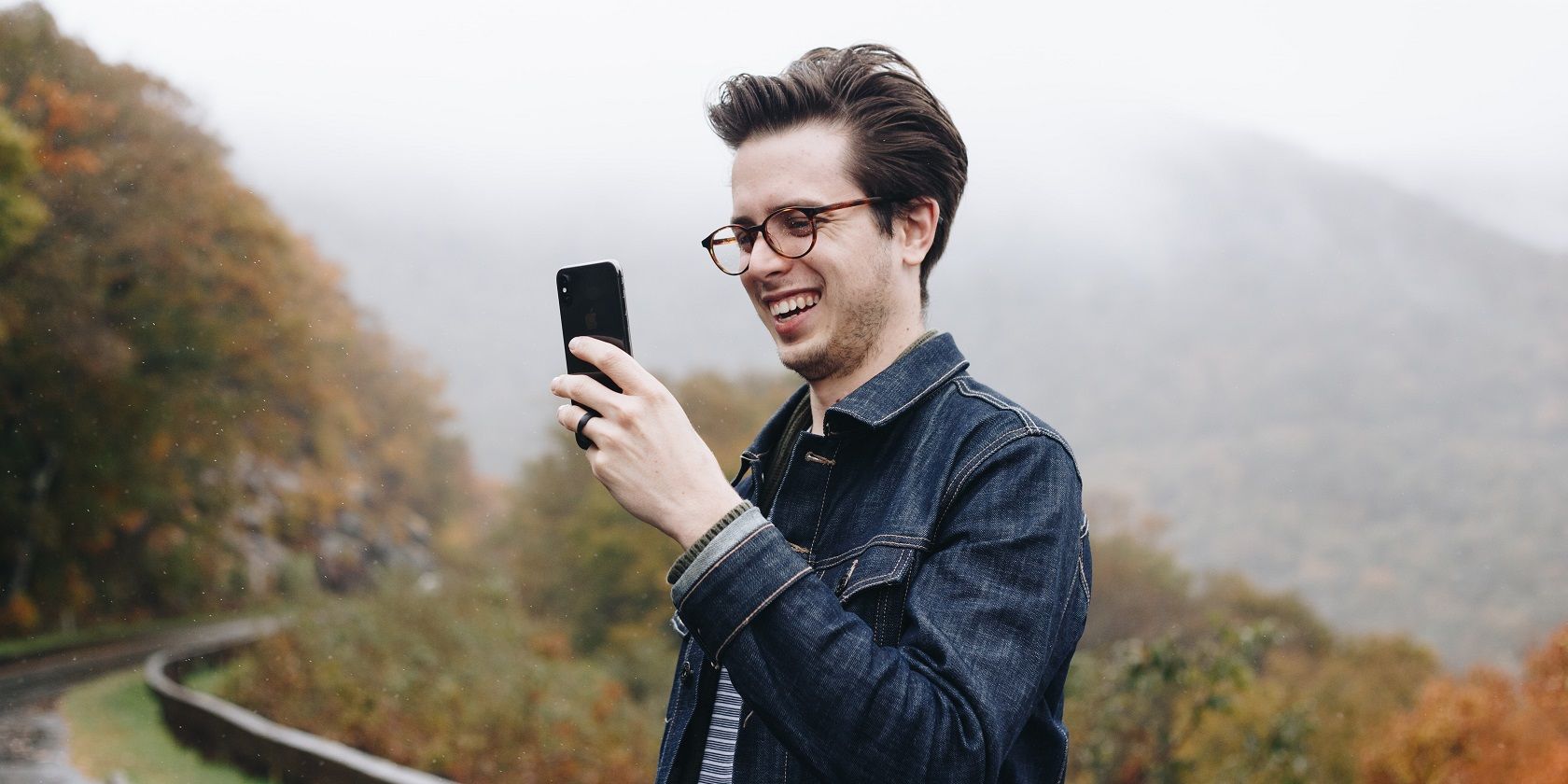 man-smiling-looking-at-smartphone