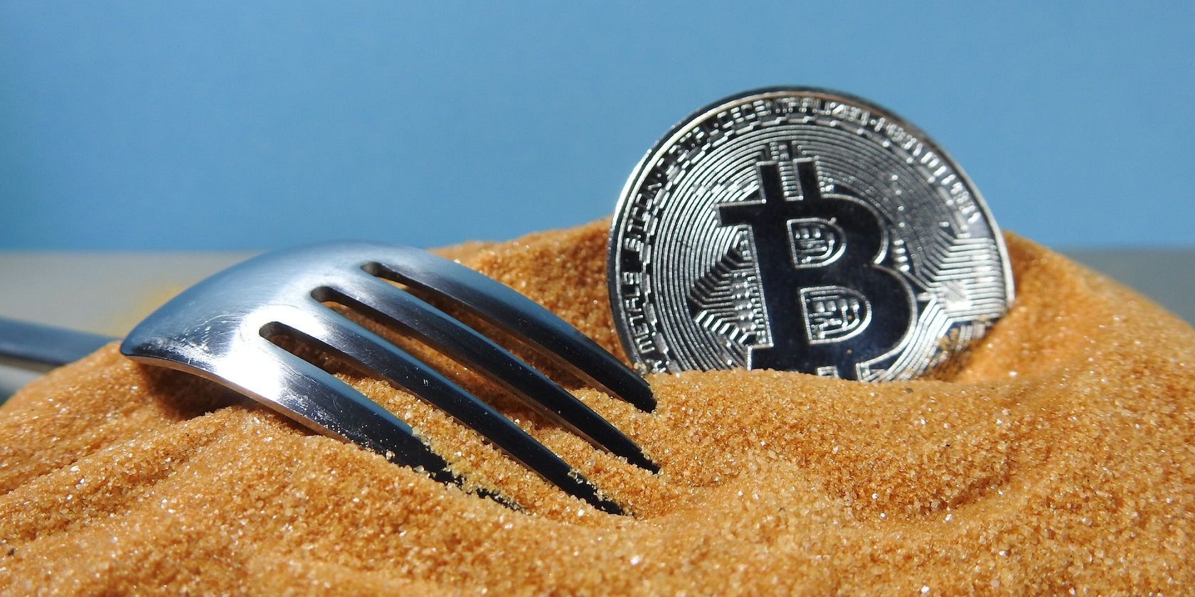 Bitcoin SegWit là gì và nó hoạt động như thế nào? Bitcoin on sand with a fork besides it