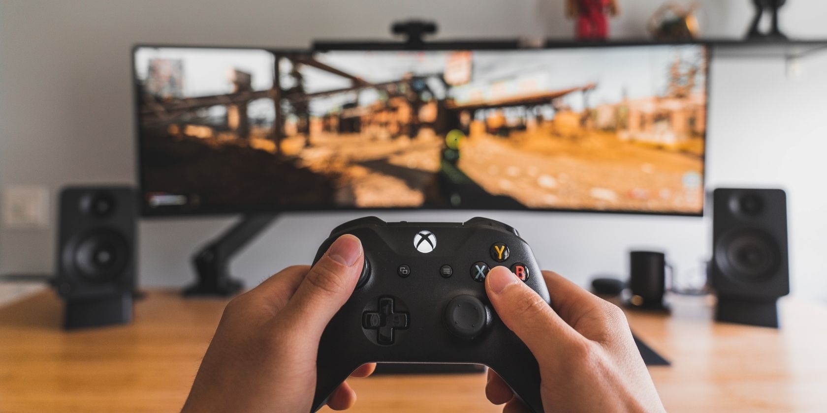 Cách kết nối Xbox Series X|S với thiết bị di động của bạn A photograph of a person holding an Xbox Wireless Controller in front of a monitor