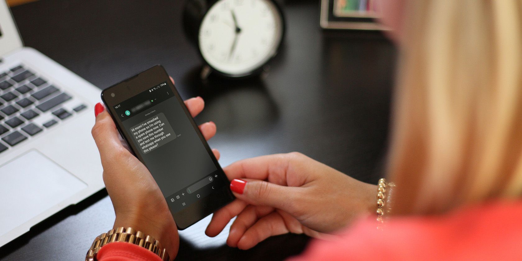người phụ nữ cầm điện thoại android với tin nhắn lừa đảo