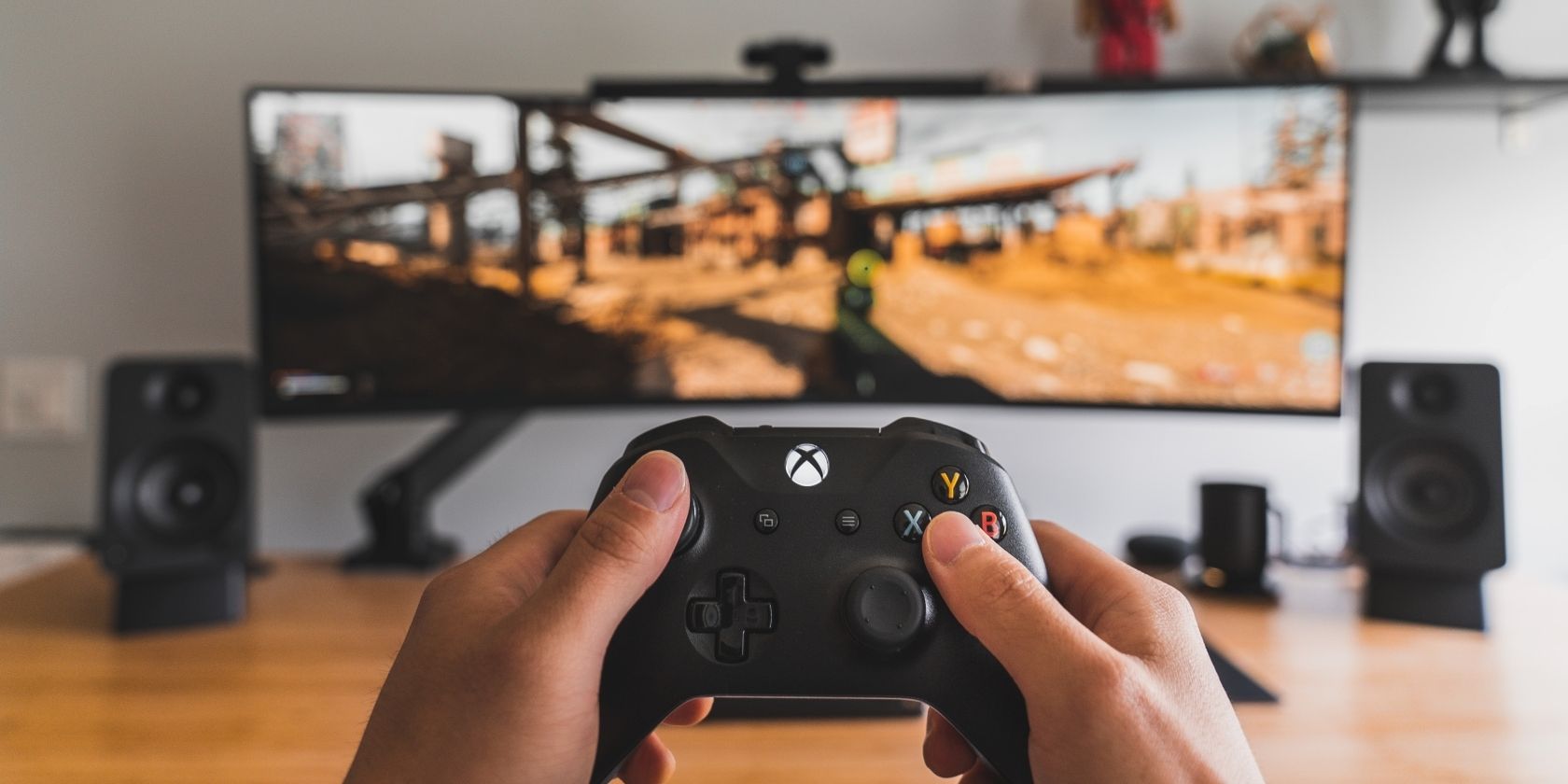 Ảnh chụp ai đó đang cầm Bộ điều khiển không dây Xbox trước màn hình