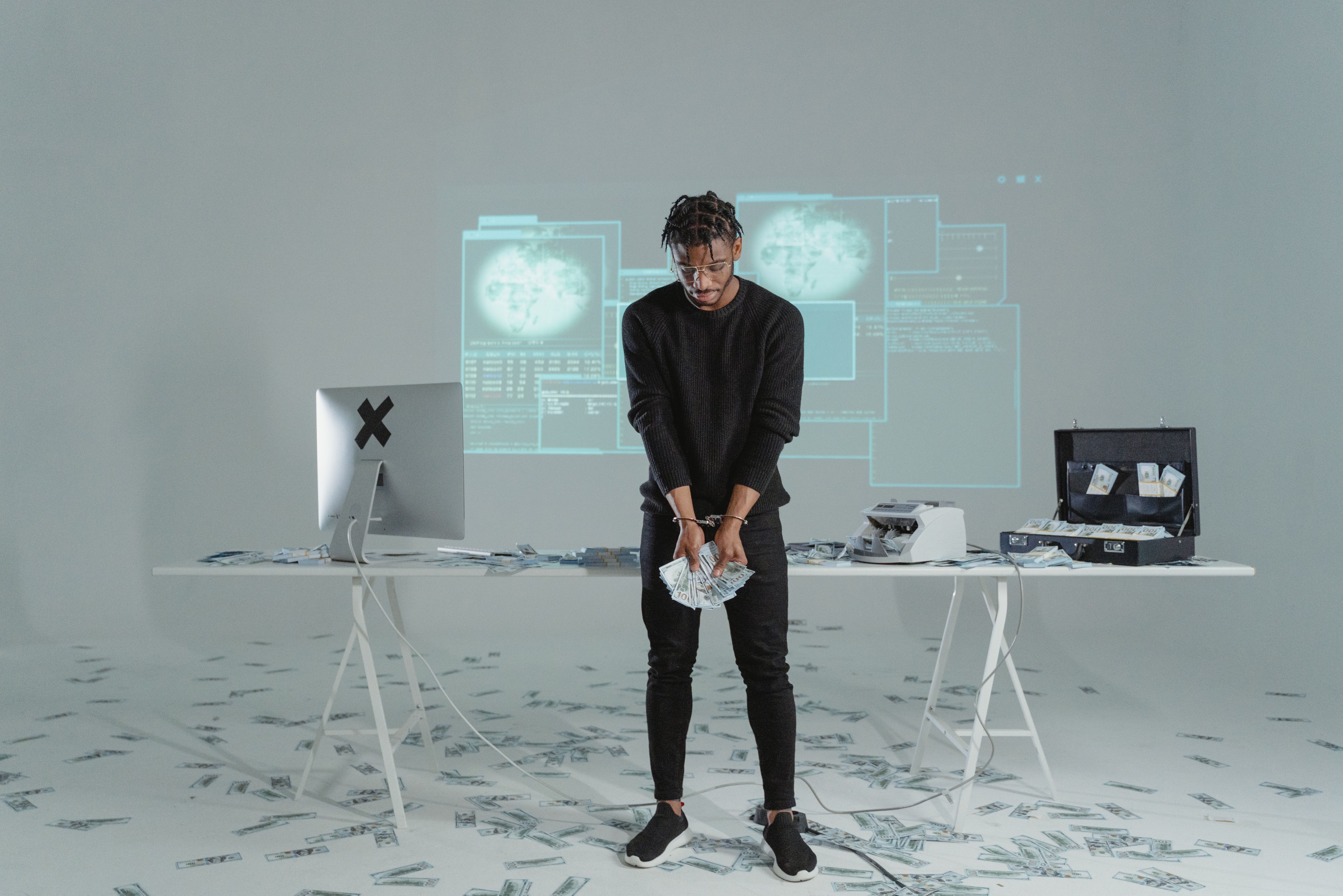 Hacker bị còng tay với những tờ tiền ăn trộm rải khắp sàn