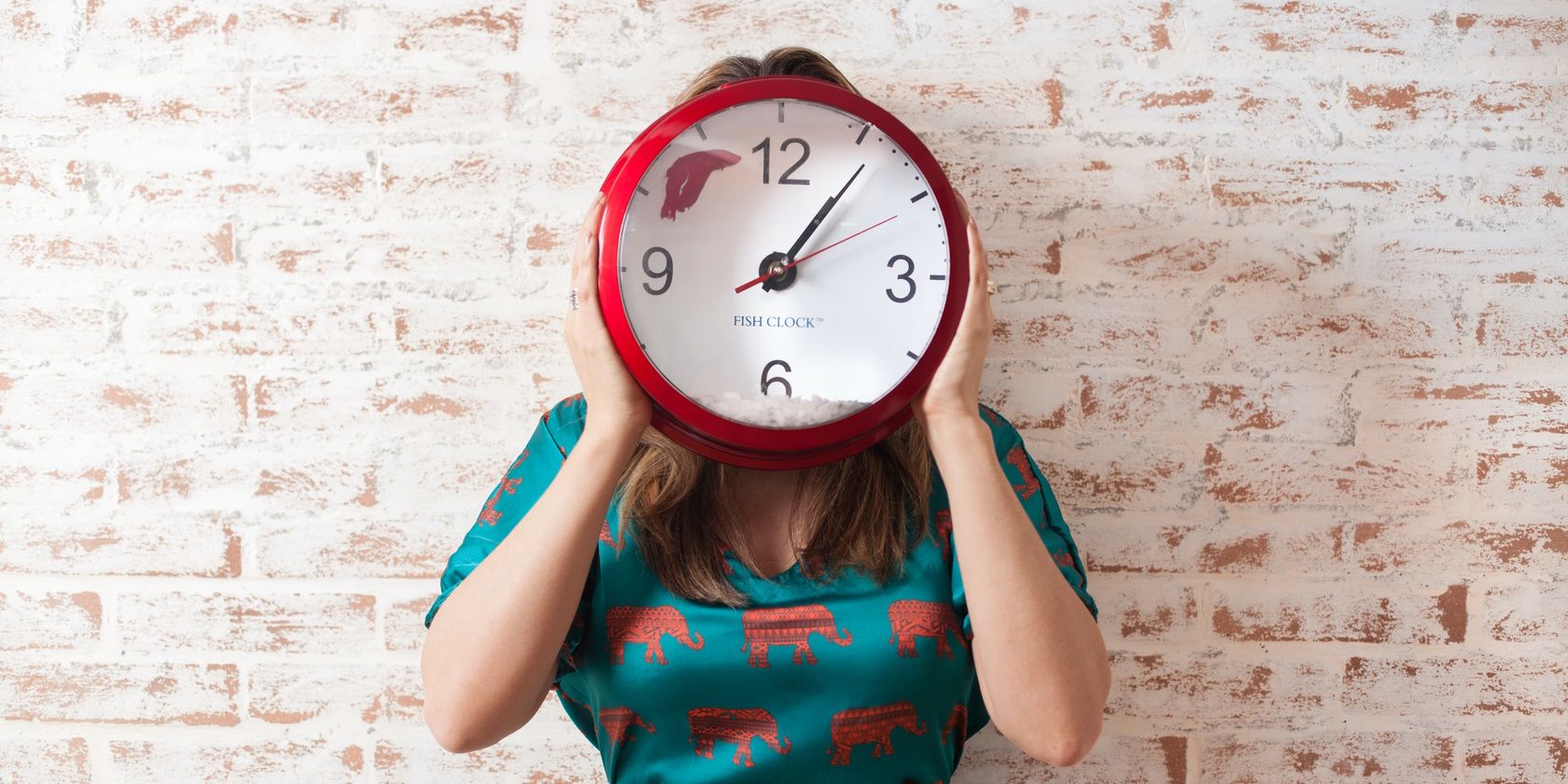 5 cách sử dụng ứng dụng đồng hồ Android để quản lý thói quen hàng ngày của bạn A woman holding a clock to her face