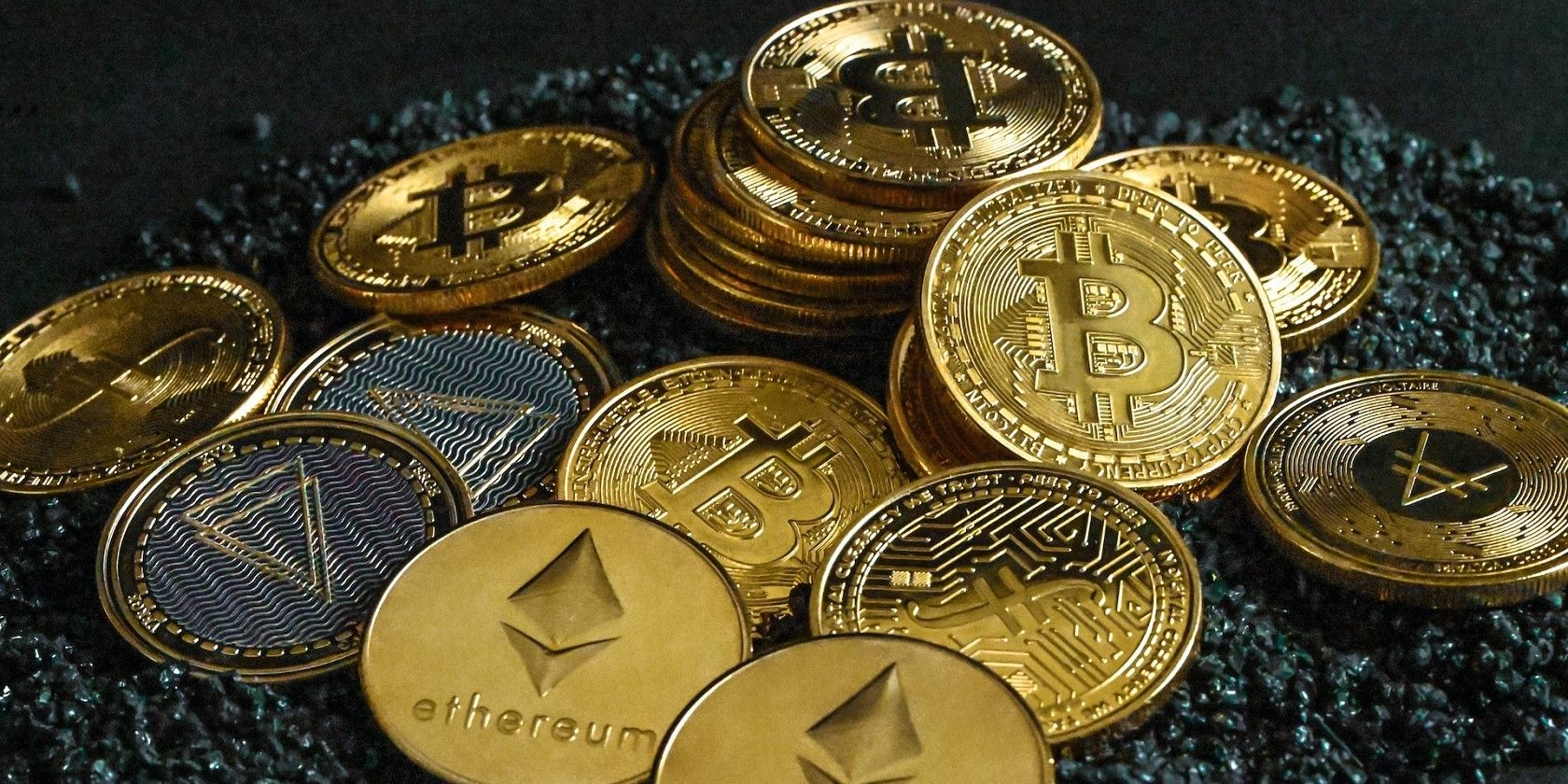 Tiêu chuẩn so với Giao thức so với Nền tảng: Sự khác biệt là gì? A group of gold cryptocurrency coins on top of black stones