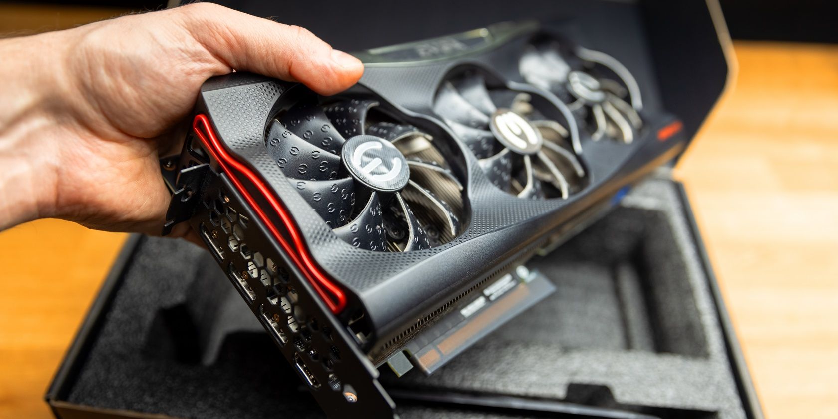 person's hand holding an Nvidia graphics card out of the box