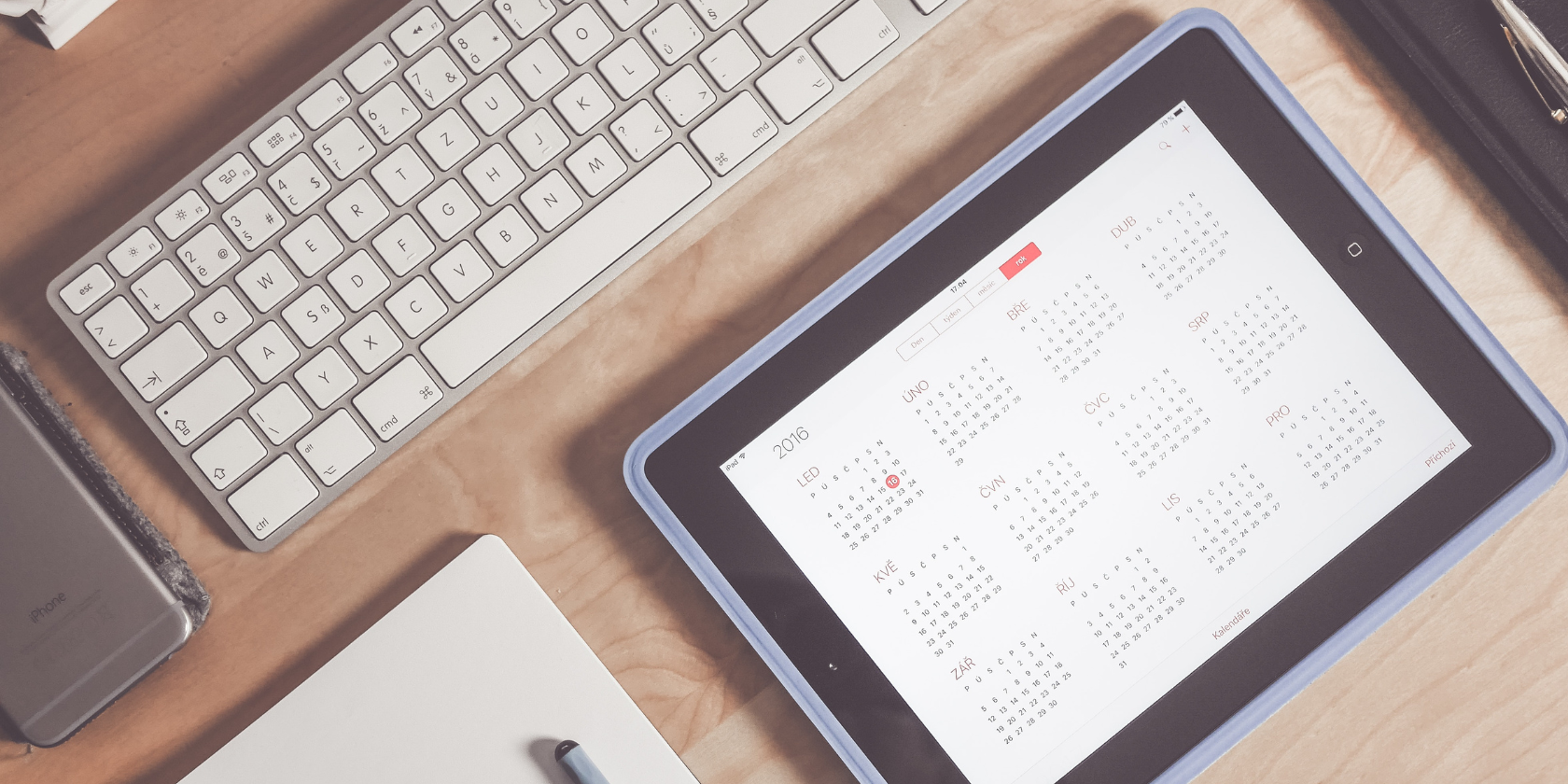 A calendar next to a phone on a table