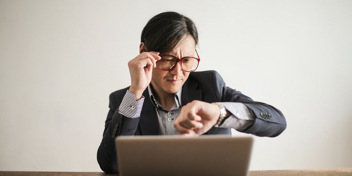 doanh nhân bối rối kiểm tra thời gian trên đồng hồ đeo tay