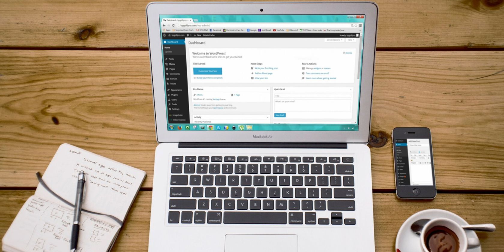 Macbook Air Nổi Bật Bên Iphone 4 Đen, Tách Trà Và Cuốn Sổ Trên Bề Mặt Gỗ Nâu