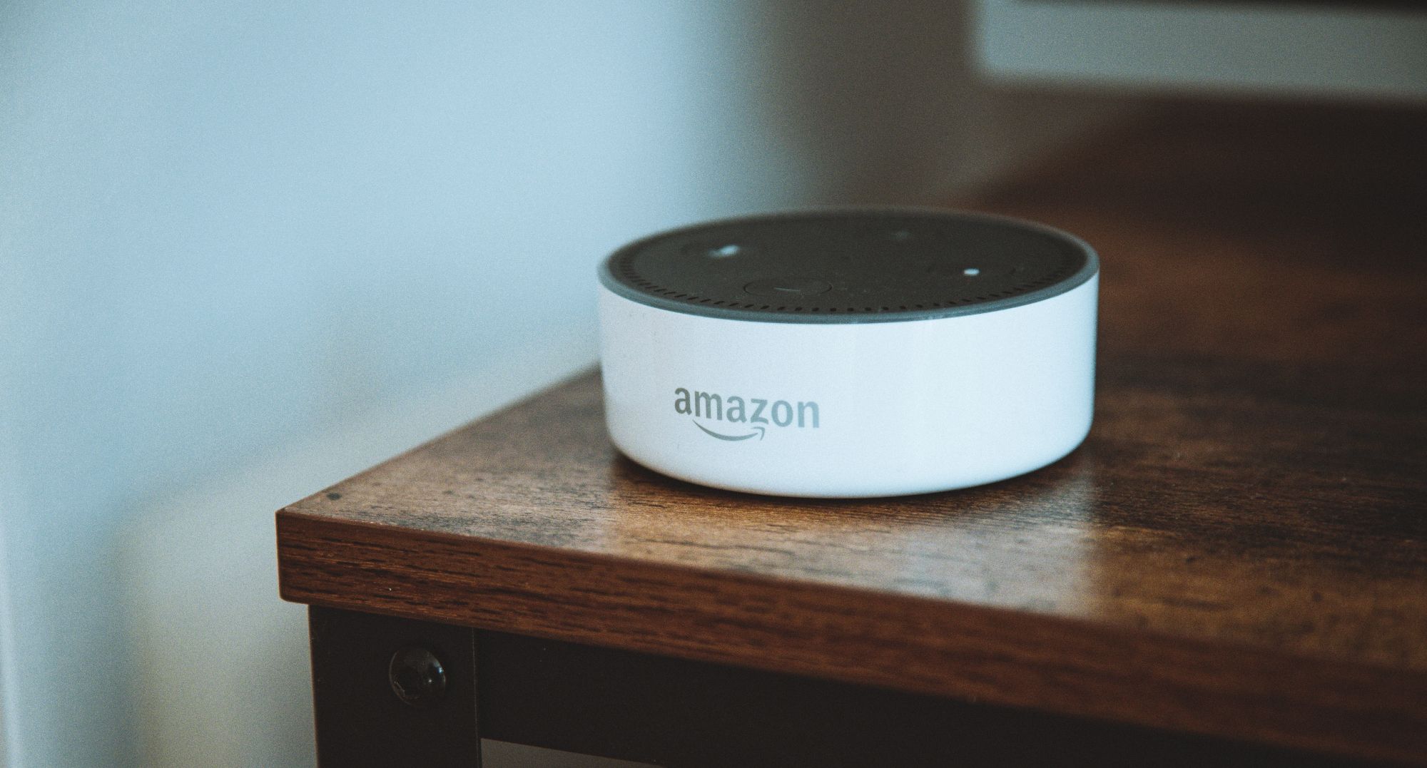 loa amazon alexa màu trắng trên bàn làm việc