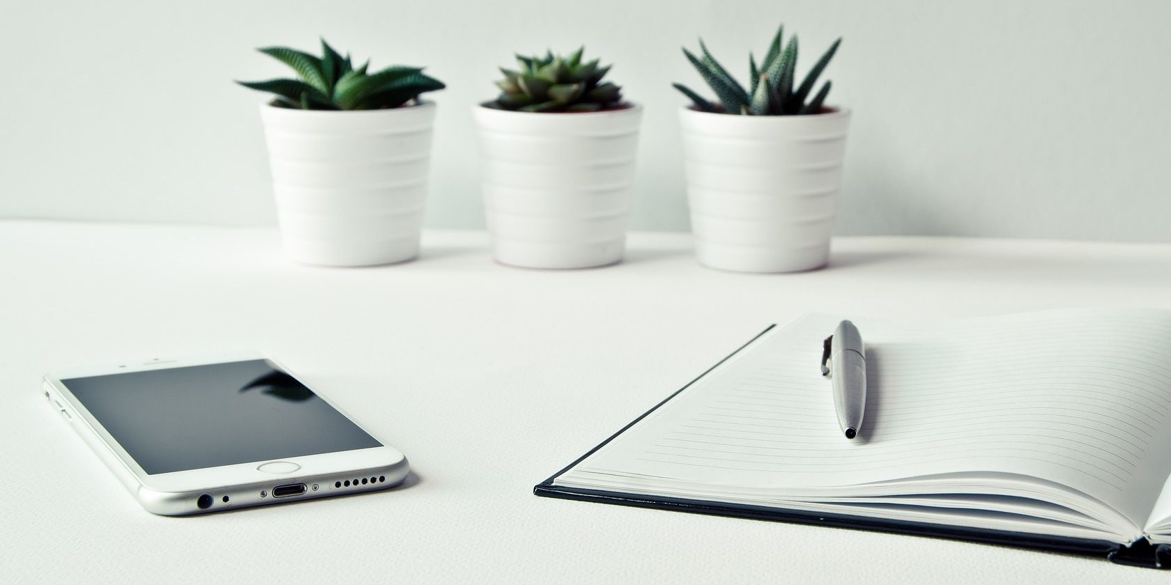 iPhone and journal on white table