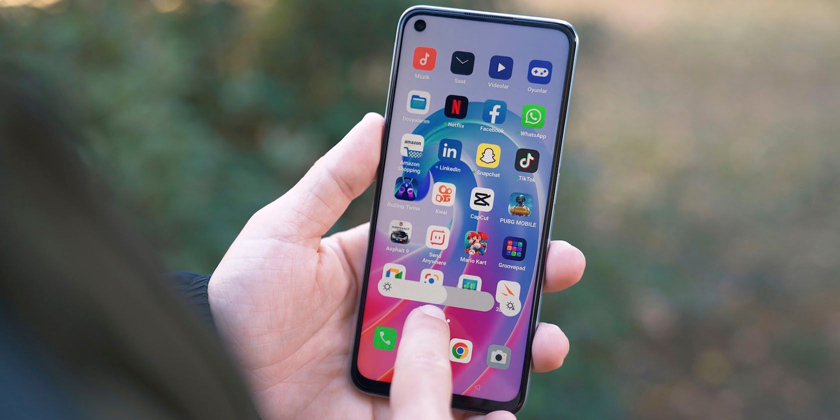 Người chỉ vào các biểu tượng ứng dụng trên màn hình chính của điện thoại Android