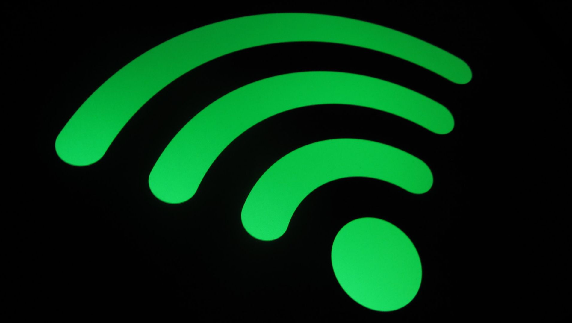 chụp cận cảnh logo wifi màu xanh lá cây trên nền đen