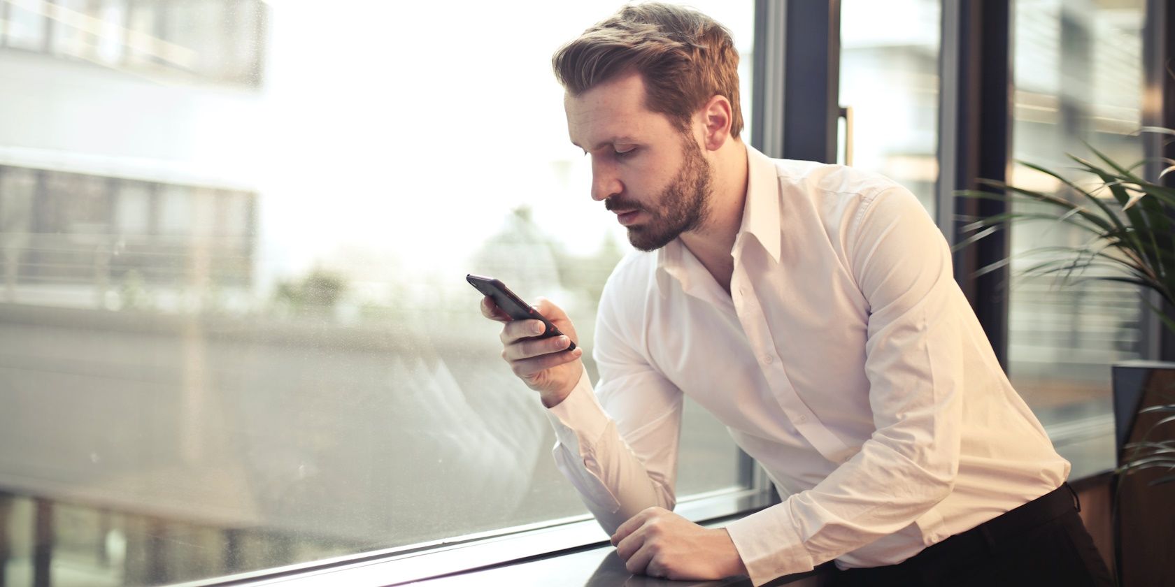 Man in a white shirt texting