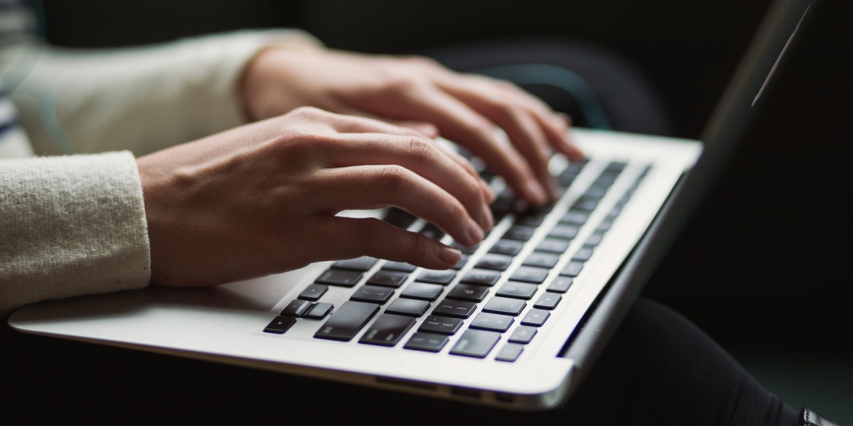 A picture of a person's hands typing on a laptop