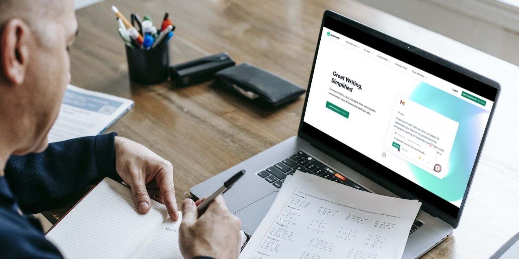 Man working with laptop displaying Grammarly homepage