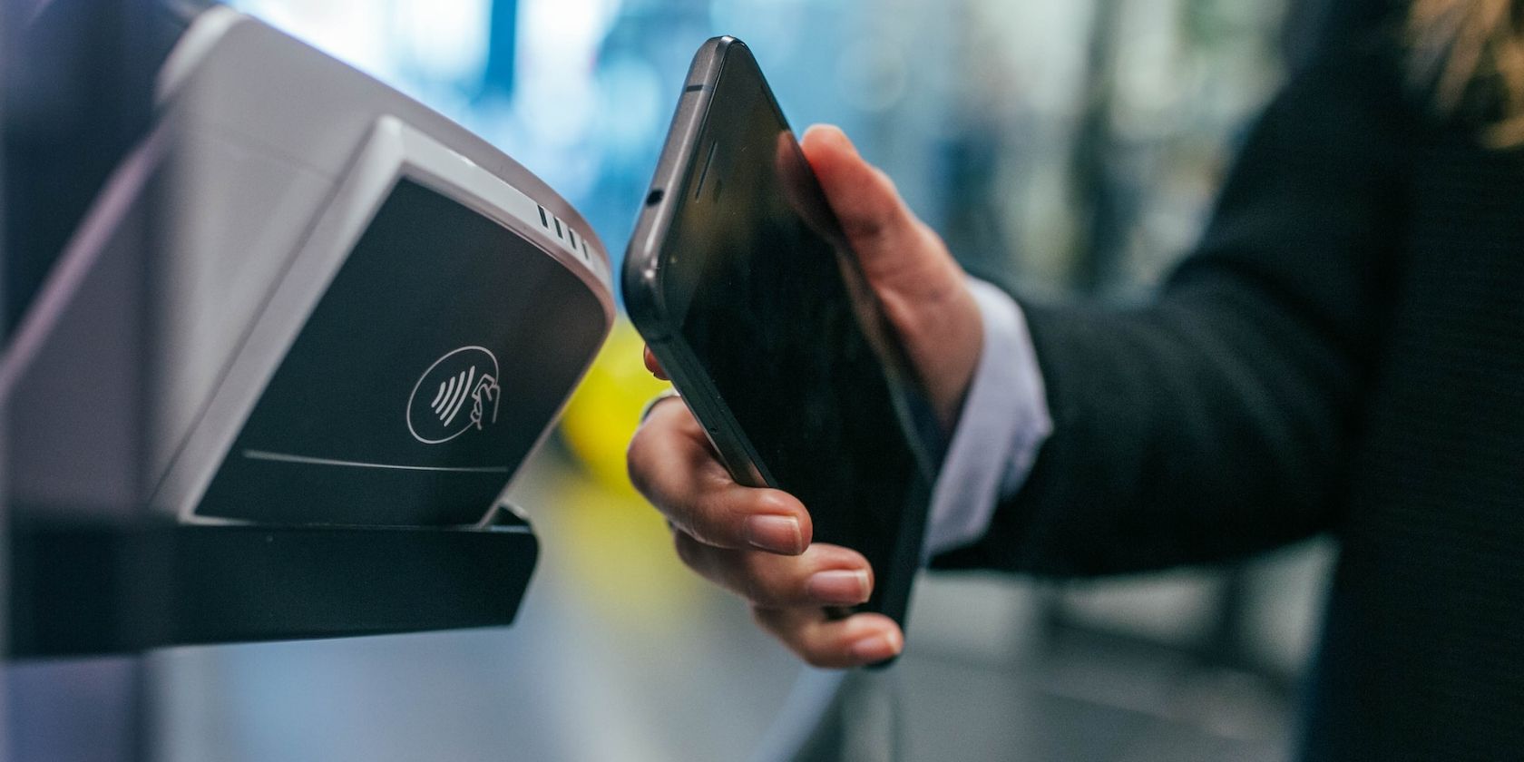 7 rủi ro bảo mật bạn cần lưu ý khi sử dụng NFC Person holding smartphone close to a payment terminal
