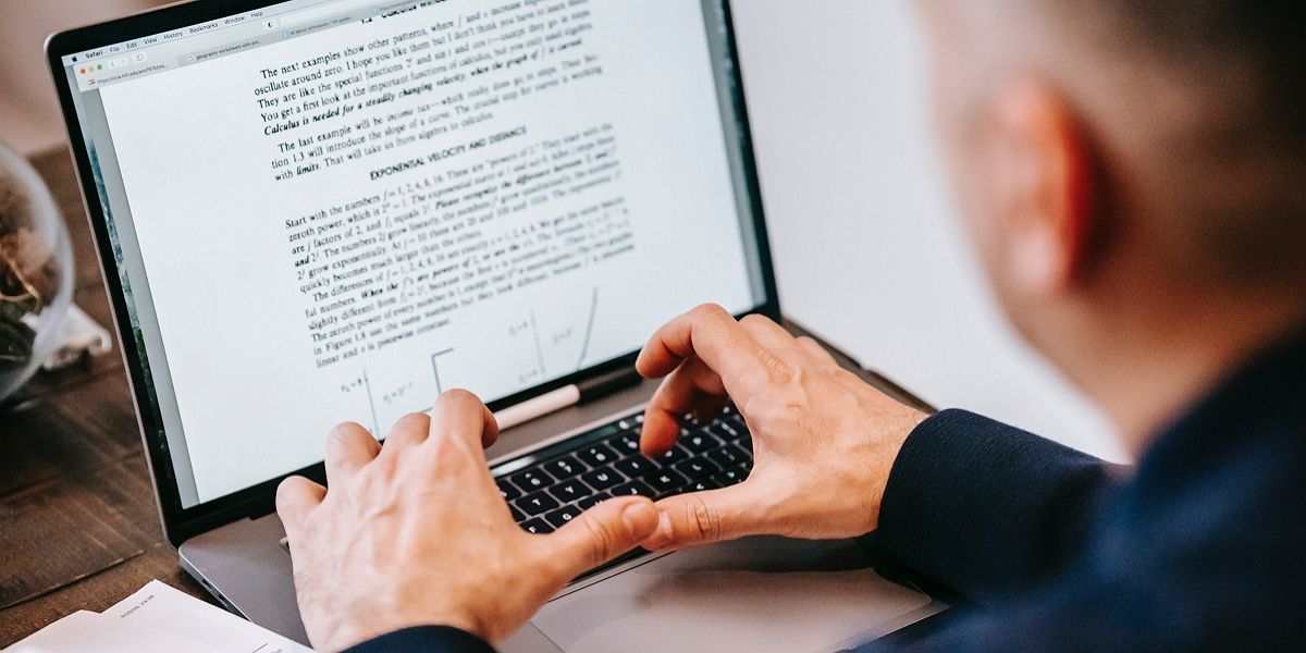 người sử dụng máy tính xách tay trên bàn gỗ