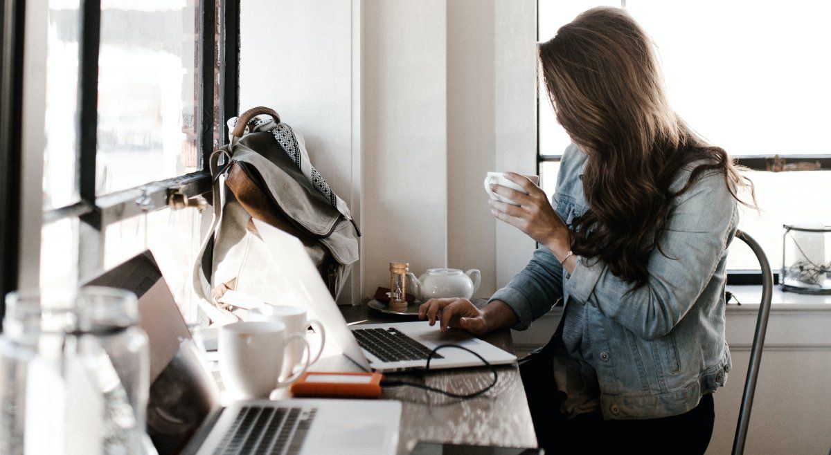 người ở máy tính uống cà phê