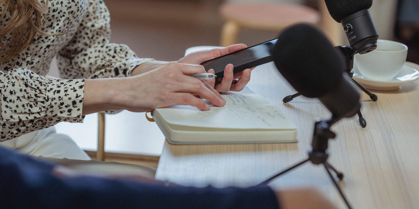 người phụ nữ sử dụng điện thoại có micrô nhỏ trên bàn