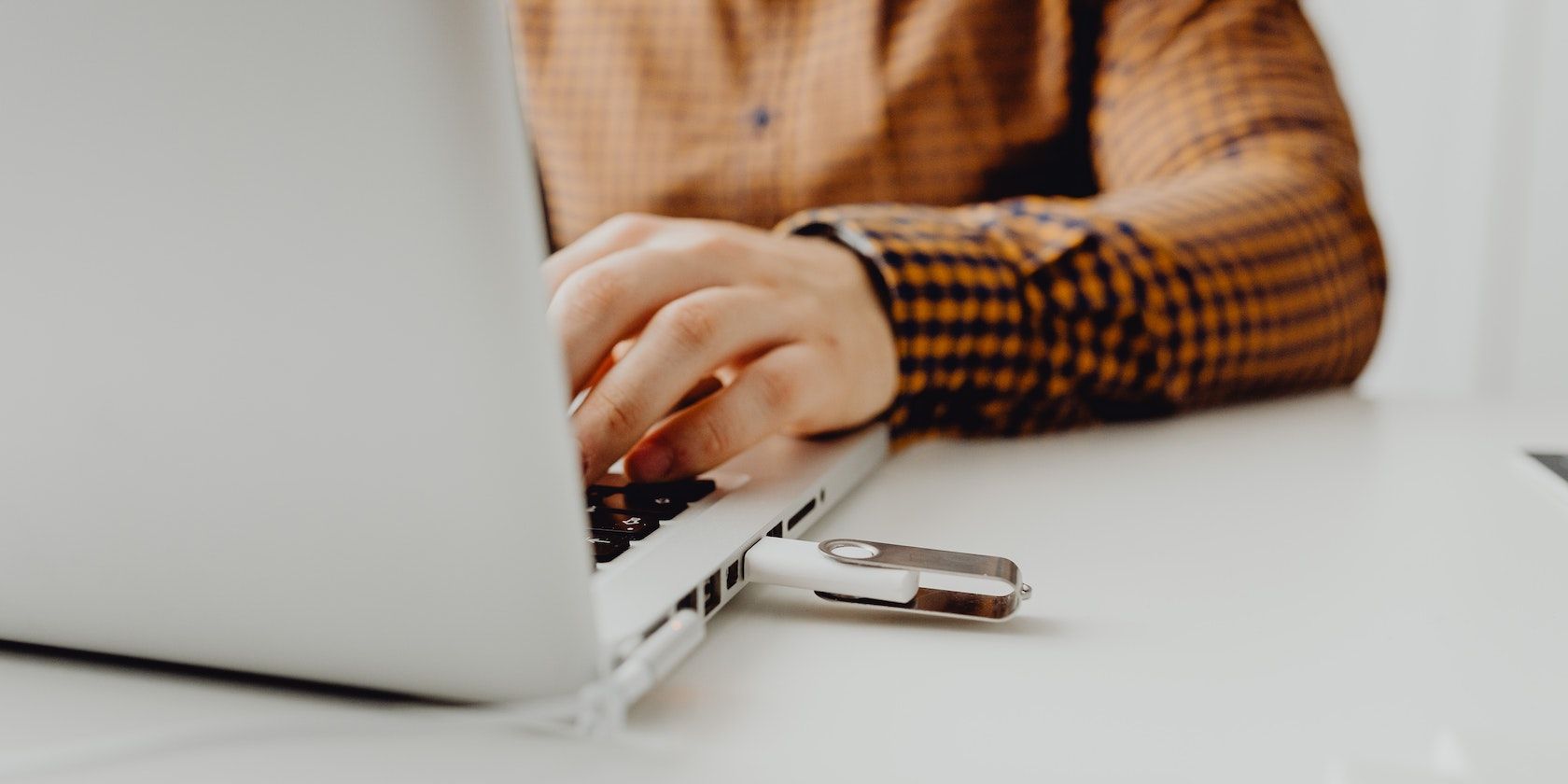 người đàn ông sử dụng máy tính xách tay có cắm ổ USB