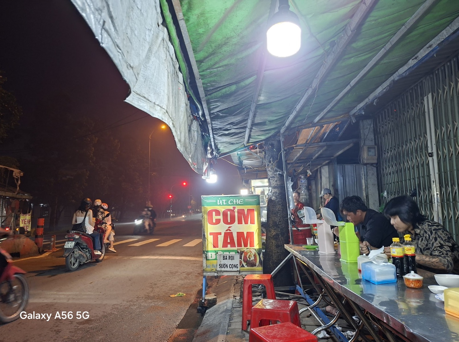 Sau một ngày rong ruổi khám phá khắp các ngóc ngách ẩm thực của Sài Gòn, mình khép lại hành trình bằng một dĩa cơm tấm nóng hổi tại một quán vỉa hè quen thuộc trên đường về. Từ xa đã có thể cảm nhận được mùi thơm ngào ngạt của sườn nướng tỏa ra từ bếp than hồng, mùi khói quyện trong không khí, từng miếng thịt cháy cạnh óng ánh mỡ khiến mình không thể cưỡng lại. Chỉ cần ngửi mùi thôi cũng đủ khiến bụng sôi ùng ục, còn đôi mắt thì không rời nổi cảnh nướng sườn đầy mê hoặc ấy.